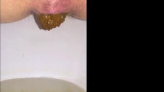 Amateur scat girl pushes out long turd closeup in toilet bowl